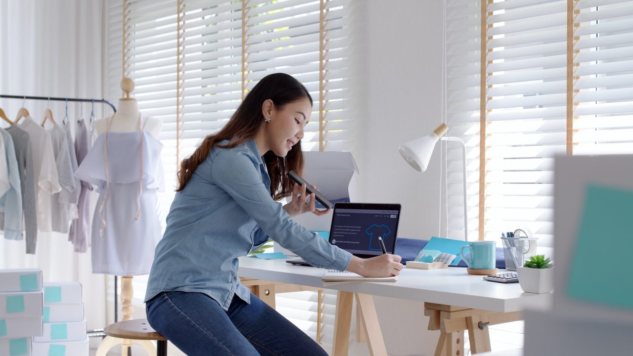 young-asia-seller-woman-happy-work-on-laptop-busy-cellphone-call-chat-to-customer.jpg